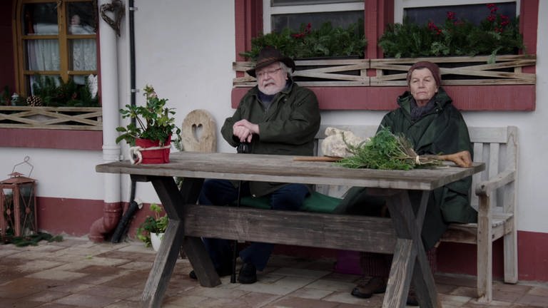 Hermann und Lioba sitzen auf der Bank vor dem Fallerhof.