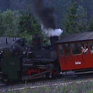 Lokomotive schiebt einen Wagon einen steilen Berg hinauf