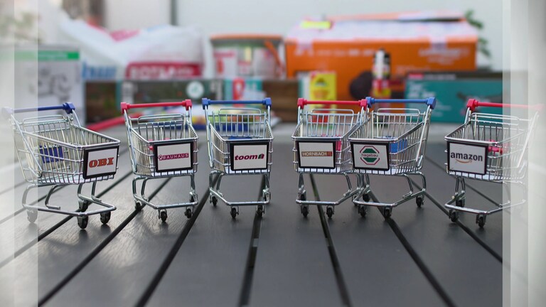Spielzeug-Einkaufswagen stehen auf einem Tisch. Welcher Baumarkt hat am Besten abgeschnitten? 