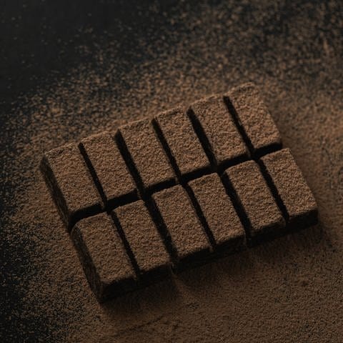 Eine Tafel dunkle Schokolade mit Kakaopuder überstäubt